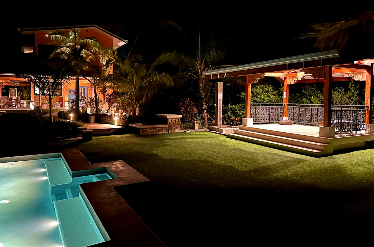 An illuminated pool and outdoor pavilion at The Sanctuary Estate at night
