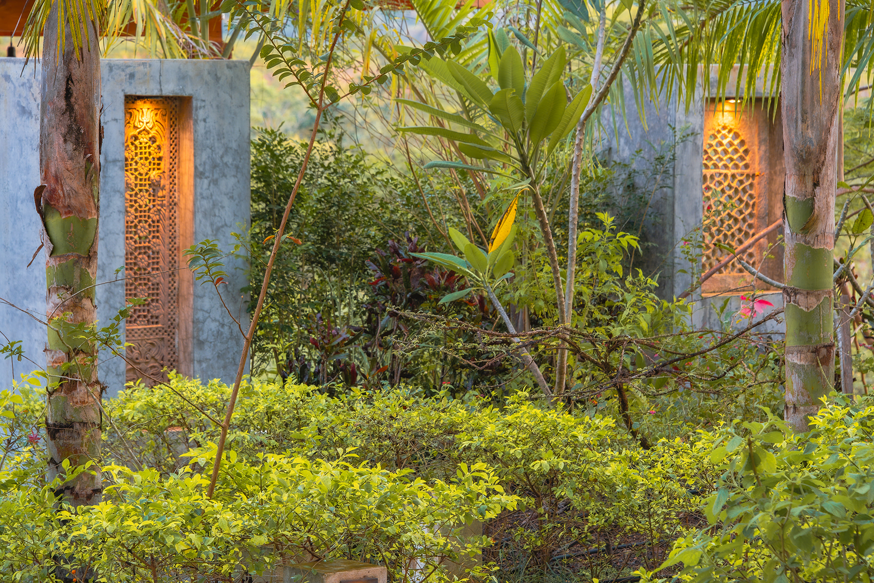 carved jali windows lit dusk — The Sanctuary Estate, Nosara, Costa Rica